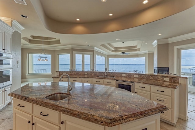 28822 Saddle Oak Dr, Montgomery, TX 77356 - kitchen featuring a sink, a raised ceiling, and an island with sink