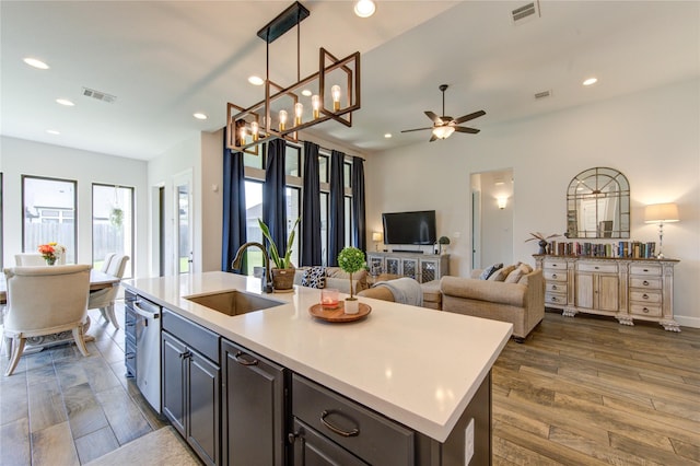 kitchen featuring ceiling fan, visible vents, open floor plan, and a sink
