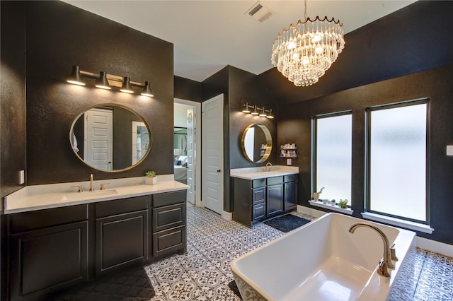 full bath featuring a bathing tub, a sink, two vanities, visible vents, and a chandelier