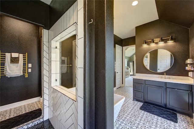 bathroom with lofted ceiling, tile patterned flooring, vanity, a tub, and a textured wall