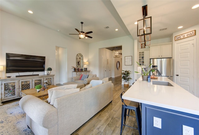 living area featuring light wood finished floors, visible vents, and recessed lighting