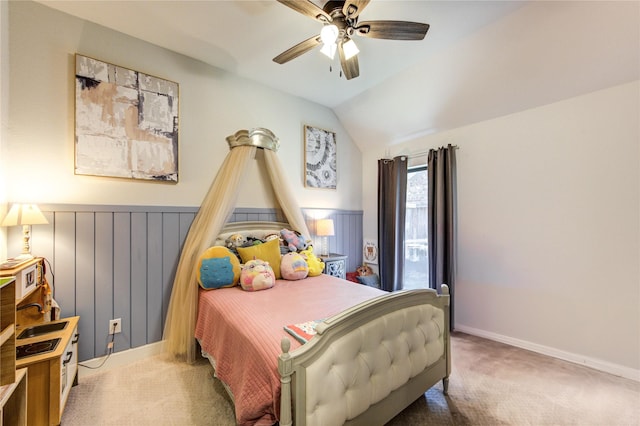 bedroom featuring a ceiling fan, lofted ceiling, baseboards, carpet flooring, and wainscoting