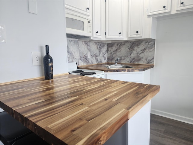 6102 Seawall Blvd Unit 213, Galveston, TX 77551 - kitchen with butcher block countertops, white appliances, dark wood finished floors, a sink, and white cabinets