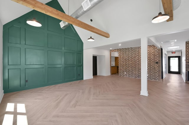 917 Houston St, Conroe, TX 77301 - unfurnished living room with a towering ceiling, brick wall, visible vents, and a decorative wall