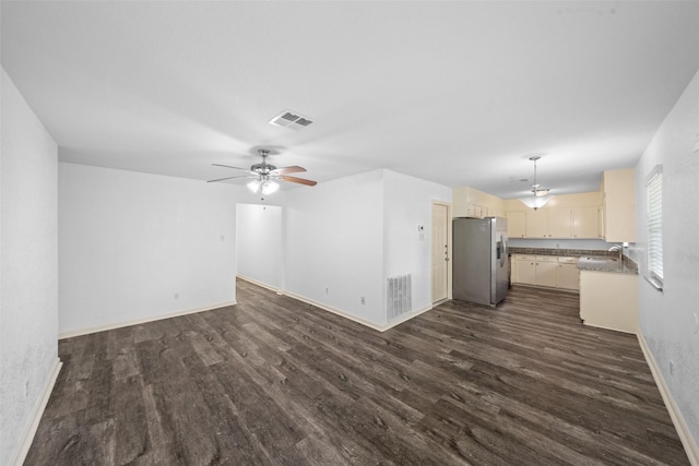 unfurnished living room featuring a sink, ceiling fan, dark wood-type flooring, and visible vents