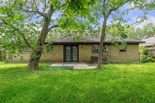 rear view of house featuring french doors, roof with shingles, a lawn, fence, and a patio