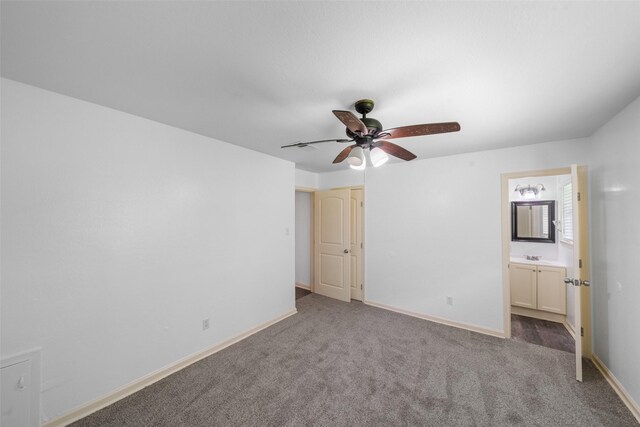 unfurnished bedroom featuring carpet floors, a ceiling fan, baseboards, and ensuite bath