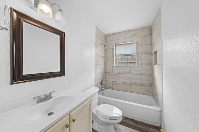 full bathroom with wood finished floors, vanity, toilet, shower / bathtub combination, and a textured wall