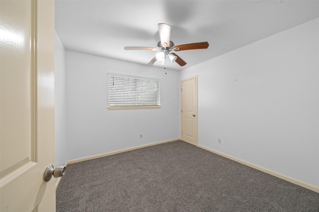 carpeted spare room featuring a ceiling fan and baseboards