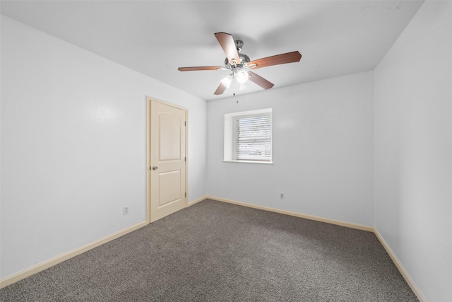 carpeted spare room with baseboards and a ceiling fan