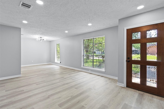 entryway with recessed lighting, a textured ceiling, and light wood finished floors