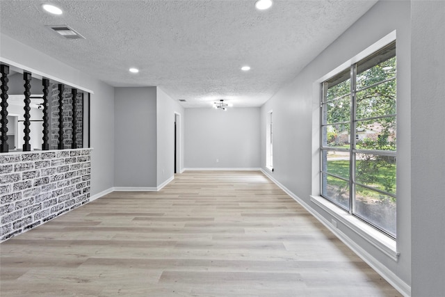 empty room with recessed lighting, a textured ceiling, visible vents, and a wealth of natural light