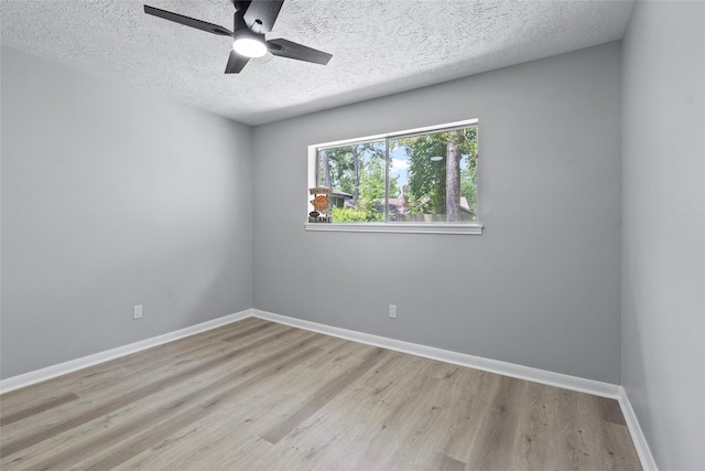 empty room featuring baseboards, a textured ceiling, ceiling fan, and wood finished floors