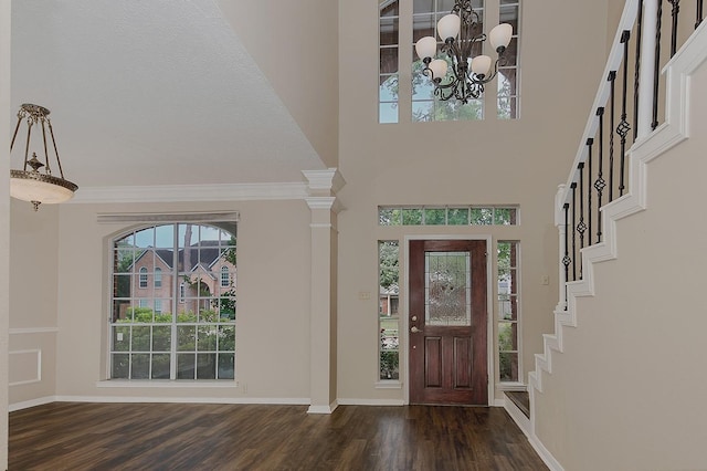 foyer entrance with stairs, a towering ceiling, wood finished floors, and a notable chandelier