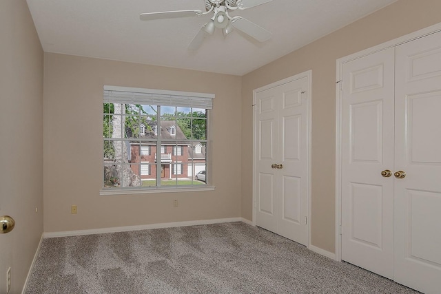 unfurnished bedroom featuring carpet floors, baseboards, ceiling fan, and a closet