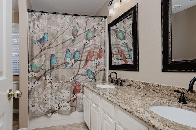 bathroom featuring a sink, double vanity, and a shower with shower curtain