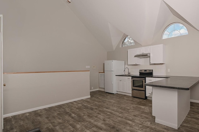 kitchen featuring freestanding refrigerator, a peninsula, dark countertops, high vaulted ceiling, and stainless steel electric stove