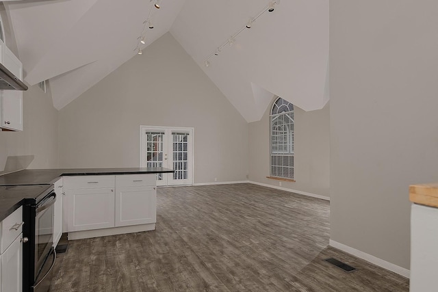 interior space with dark countertops, rail lighting, black electric range, baseboards, and visible vents