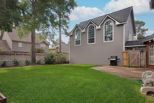 exterior space with fence, a patio, a shingled roof, a gate, and a yard