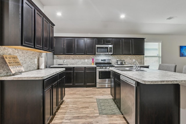 6011 Diantha St, Katy, TX 77449 - kitchen with appliances with stainless steel finishes, a sink, light countertops, light wood-type flooring, and tasteful backsplash