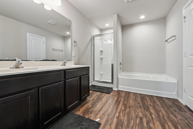 6011 Diantha St, Katy, TX 77449 - bathroom featuring a stall shower, a bath, wood finished floors, double vanity, and recessed lighting
