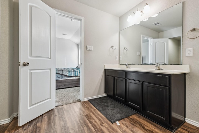 6011 Diantha St, Katy, TX 77449 - ensuite bathroom featuring wood finished floors, double vanity, and baseboards