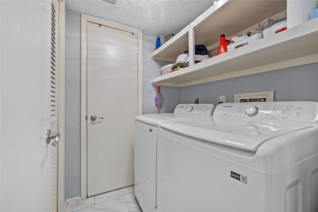 washroom with laundry area, marble finish floor, a textured ceiling, and washer and clothes dryer