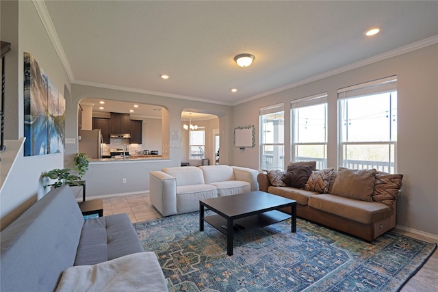 living room with crown molding, arched walkways, and recessed lighting