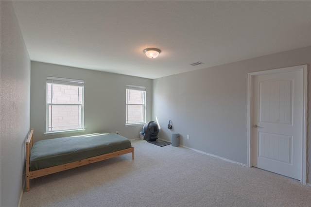 carpeted bedroom with baseboards and visible vents