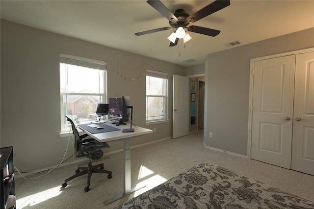 office area with baseboards, visible vents, a ceiling fan, and light colored carpet