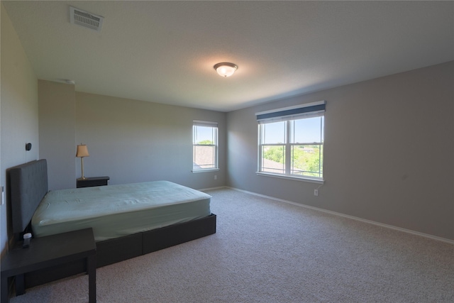 carpeted bedroom featuring baseboards and visible vents