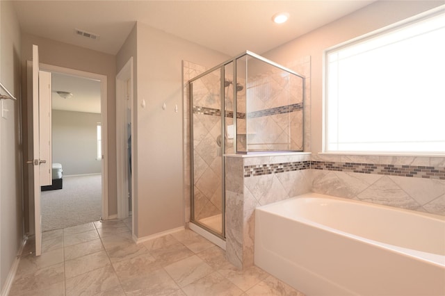 bathroom with baseboards, a stall shower, a garden tub, and visible vents
