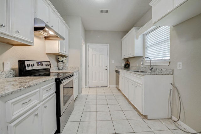 7315 Palestine St, Houston, TX 77020 - kitchen with appliances with stainless steel finishes, a sink, under cabinet range hood, light tile patterned floors, and white cabinets