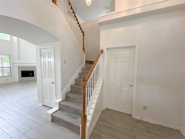 5310 Flagridge Ln, Houston, TX 77066 - stairs with wood finished floors, baseboards, a fireplace, arched walkways, and a towering ceiling