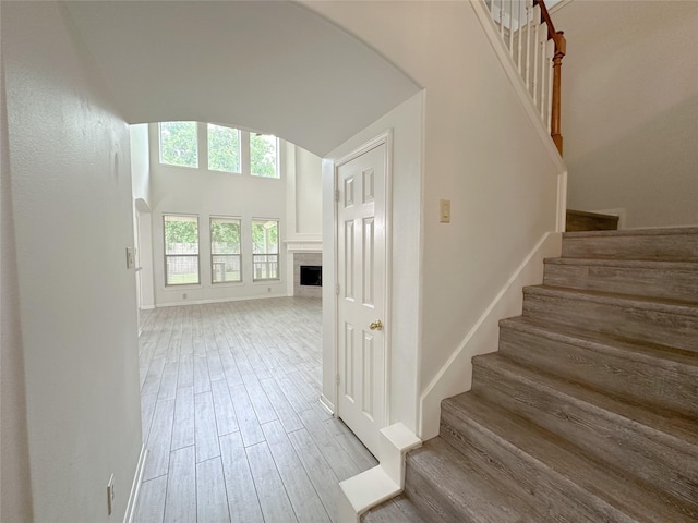 5310 Flagridge Ln, Houston, TX 77066 - staircase with wood finished floors, a fireplace, vaulted ceiling, arched walkways, and baseboards