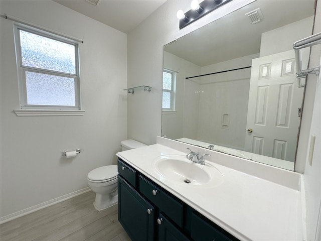 5310 Flagridge Ln, Houston, TX 77066 - bathroom featuring baseboards, wood finished floors, toilet, vanity, and a shower