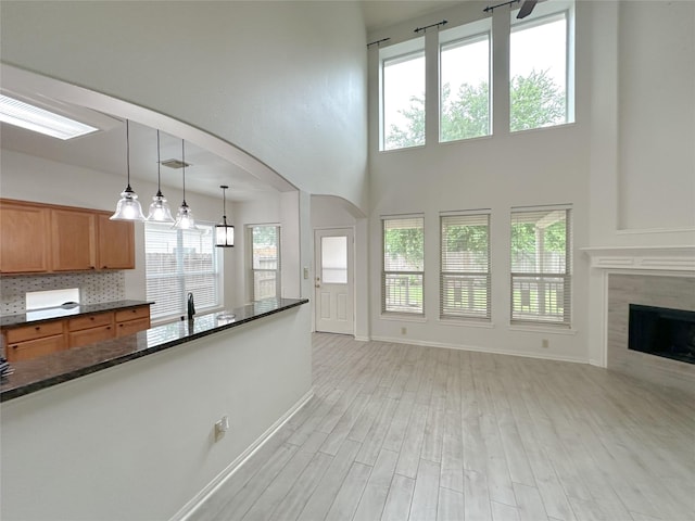 5310 Flagridge Ln, Houston, TX 77066 - unfurnished living room with baseboards, light wood-type flooring, healthy amount of natural light, a high ceiling, and a sink