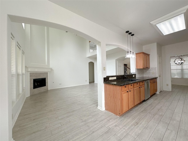 5310 Flagridge Ln, Houston, TX 77066 - kitchen featuring a sink, stainless steel dishwasher, arched walkways, and light wood-style flooring