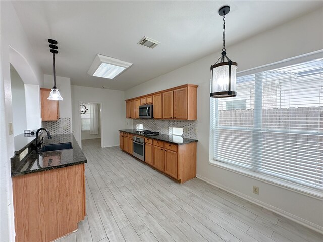 5310 Flagridge Ln, Houston, TX 77066 - kitchen with stainless steel appliances, decorative backsplash, a sink, and light wood-type flooring