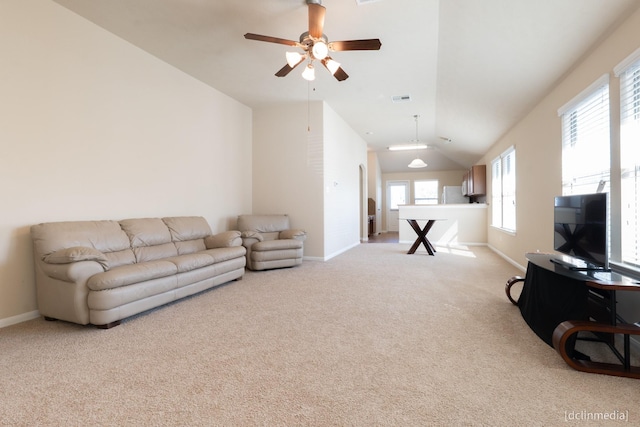 living area featuring ceiling fan, visible vents, light colored carpet, baseboards, and lofted ceiling
