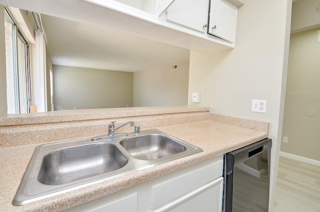 1950 Spenwick Dr Unit 302, Houston, TX 77055 - kitchen with light wood-type flooring, light countertops, white cabinets, a sink, and dishwasher