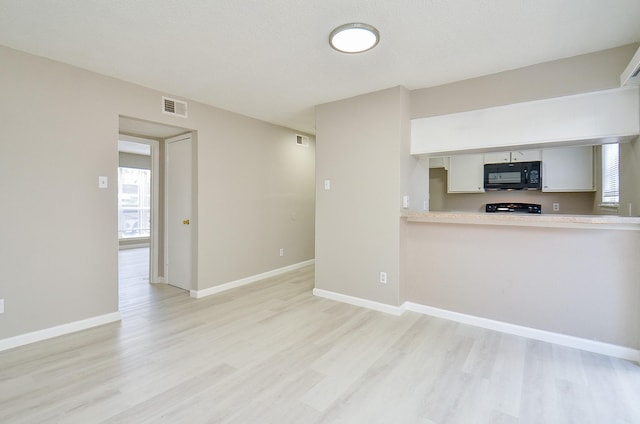 1950 Spenwick Dr Unit 302, Houston, TX 77055 - unfurnished living room featuring baseboards, visible vents, and light wood finished floors