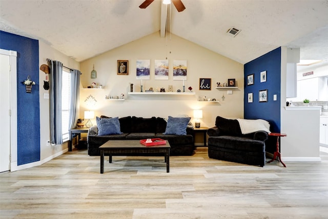 living area with vaulted ceiling with beams, ceiling fan, wood finished floors, and visible vents