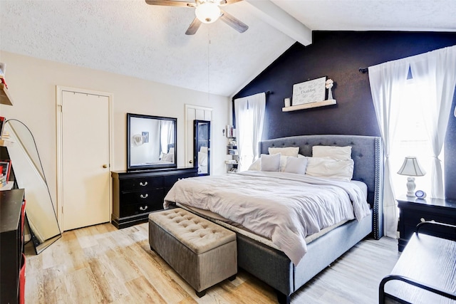 bedroom with ceiling fan, lofted ceiling with beams, and light wood finished floors