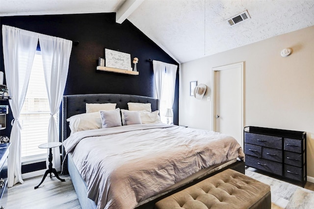 bedroom featuring visible vents, lofted ceiling with beams, and wood finished floors