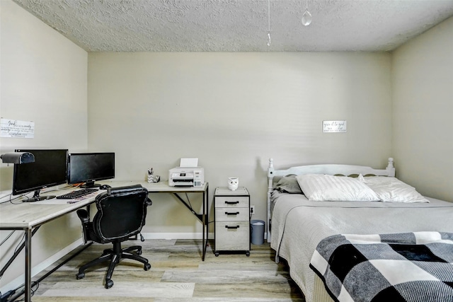 bedroom featuring light wood-type flooring and a textured ceiling