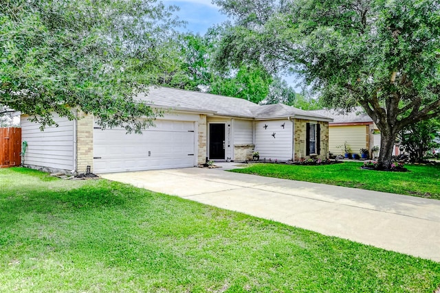 ranch-style home with an attached garage, fence, driveway, and a front yard