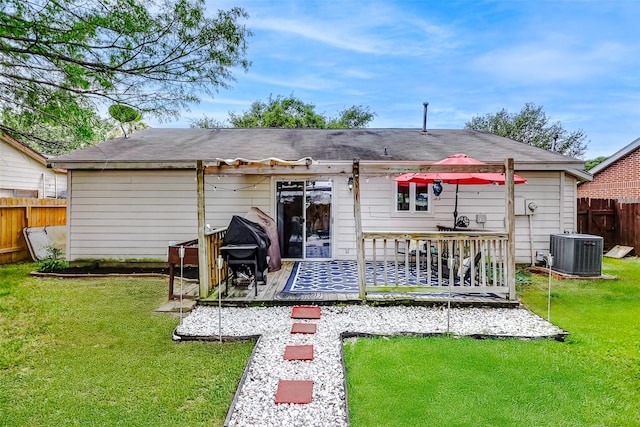 back of property with fence, a lawn, and cooling unit
