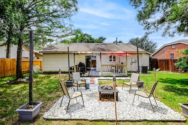back of house featuring a lawn, a patio, a fenced backyard, and an outdoor fire pit