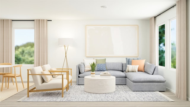 living area featuring baseboards, a healthy amount of sunlight, and wood finished floors